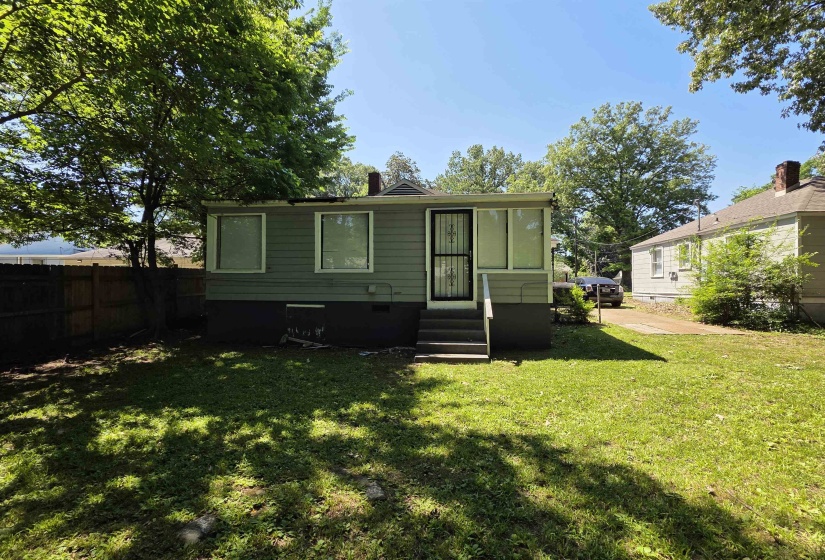 Rear exterior with light green siding and dark trim