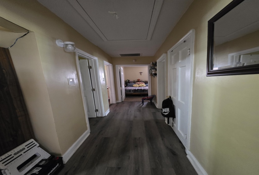 Hallway featuring wood-finish flooring and light-toned walls