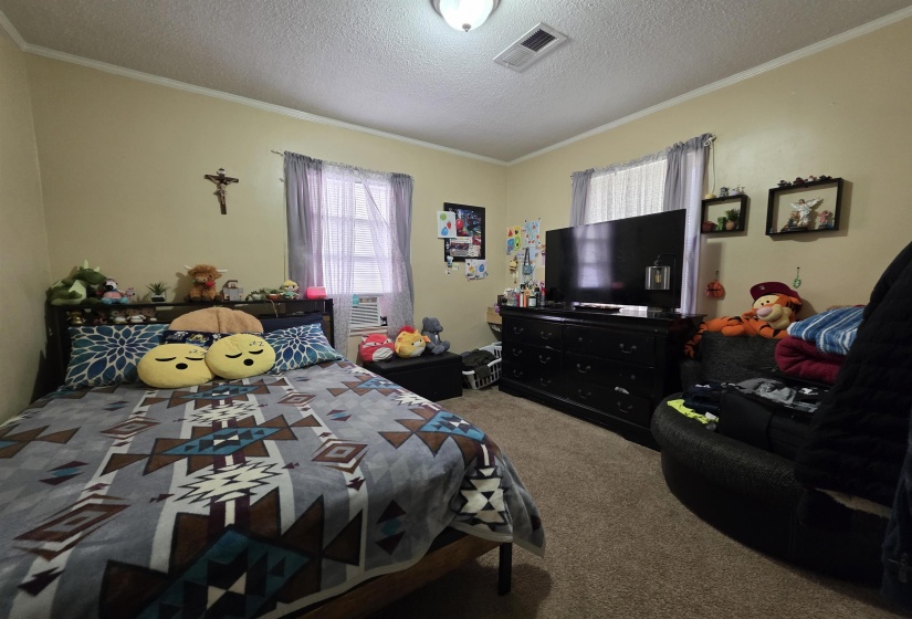 Carpeted room featuring light beige walls and white crown molding