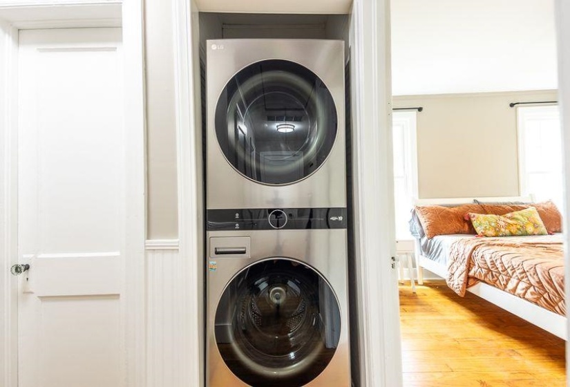 Integrated laundry closet featuring a stacked washer and dryer unit