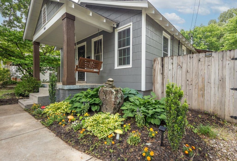 Charming exterior featuring gray horizontal siding, white trim, and a covered front porch with substantial brown columns