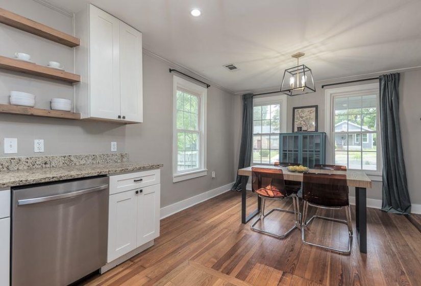 Kitchen area featuring wood-finish flooring, white cabinetry, open wood shelving, and stone countertops