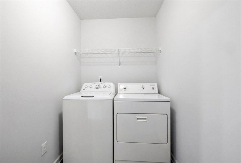 Dedicated laundry area featuring a white top-load washing machine and a white front-load dryer