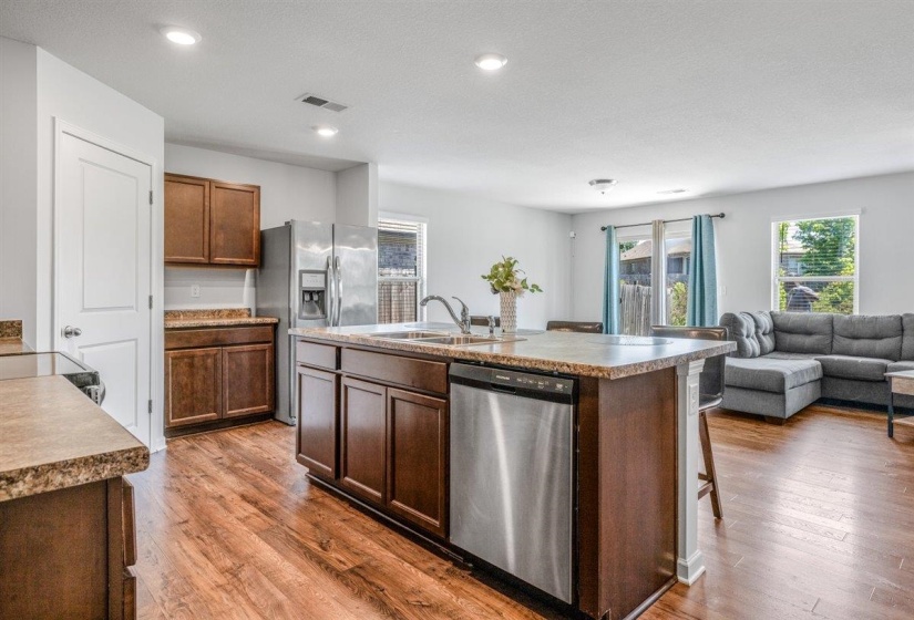 Kitchen featuring a central island with an undermount sink and stainless steel dishwasher