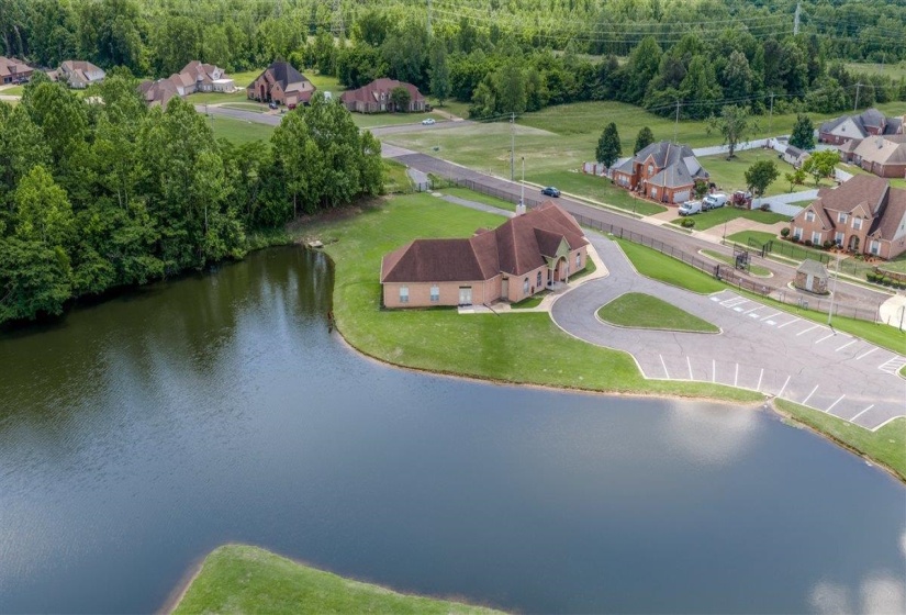 Expansive pond featuring manicured grassy banks and surrounding mature trees
