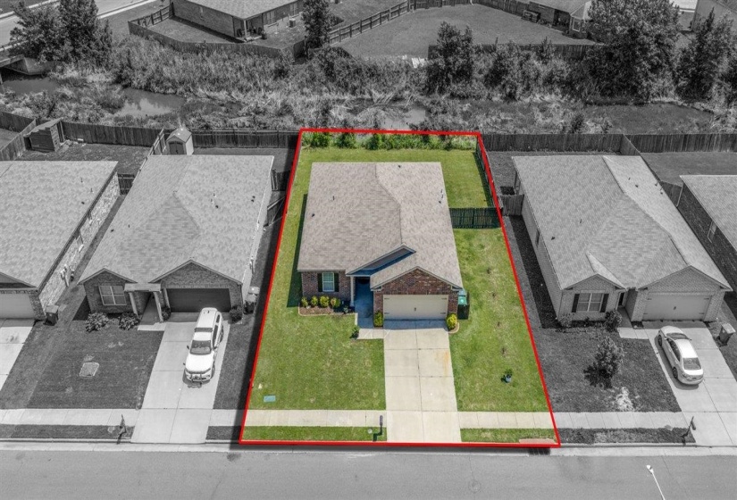Single-story residence with a brick and siding facade, featuring a two-car garage, mature landscaping, and a fenced backyard
