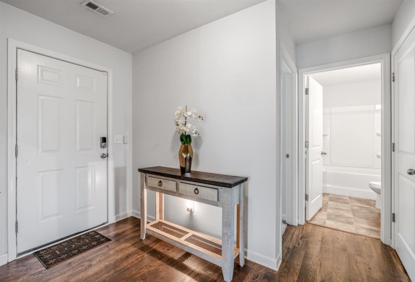 Entryway featuring wood-finish flooring and a five-panel main entry door with smart lock