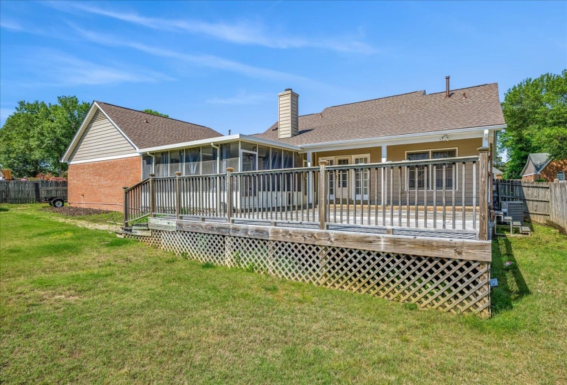 Expansive outdoor deck with lattice skirting and a screened-in porch