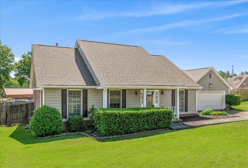 Single-story residence featuring light gray siding, dark shutters, and a covered front entry