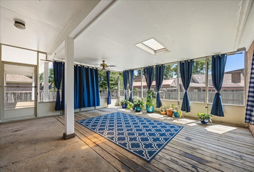 Screened porch featuring a skylight, wood-finish flooring, and a ceiling fan