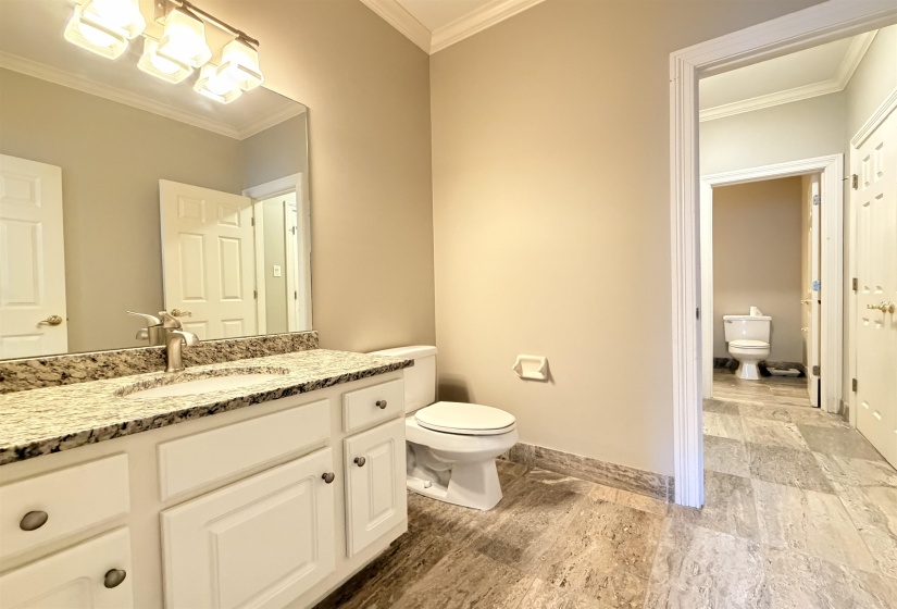 Bathroom featuring a single vanity with granite-style countertop, undermount sink, and brushed nickel faucet