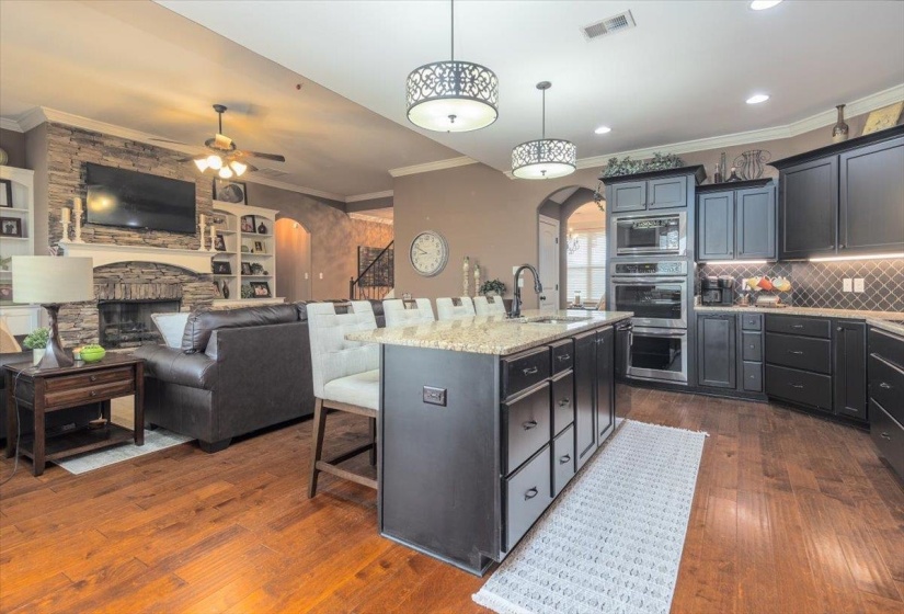 Spacious kitchen featuring dark cabinetry, a central island with countertop seating, and integrated stainless steel appliances