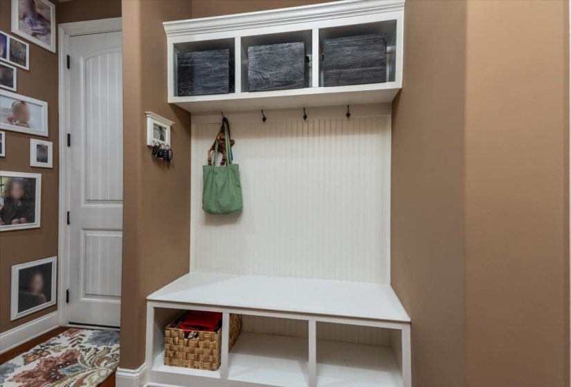 Built-in mudroom bench with beadboard backing, upper cubby storage, and lower shoe cubbies