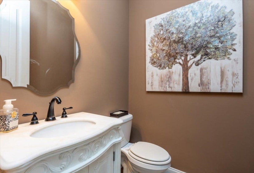 Ornate white vanity featuring a built-in sink and dark bronze faucet