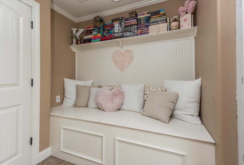 Built-in bench seating with panel detailing, beadboard wainscoting, and crown molding