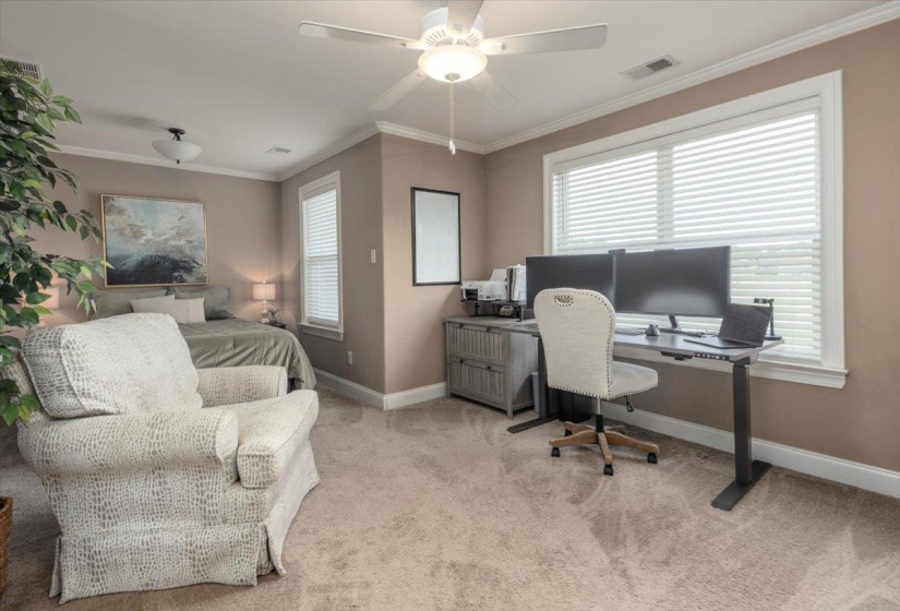 Carpeted interior room featuring warm neutral paint tones and white crown molding