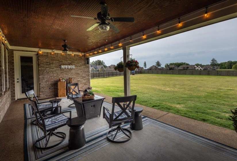 Covered patio featuring a corrugated metal ceiling and brick accent wall