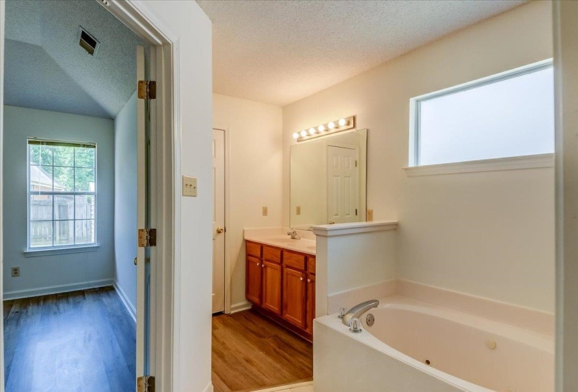 Bathroom features dual vanity with a walk-in closet