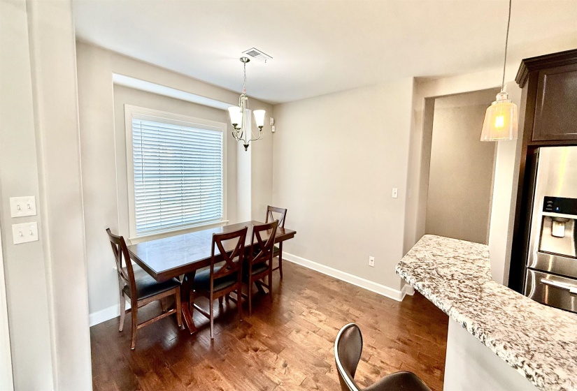 Dining space featuring dark wood finished floors and a chandelier