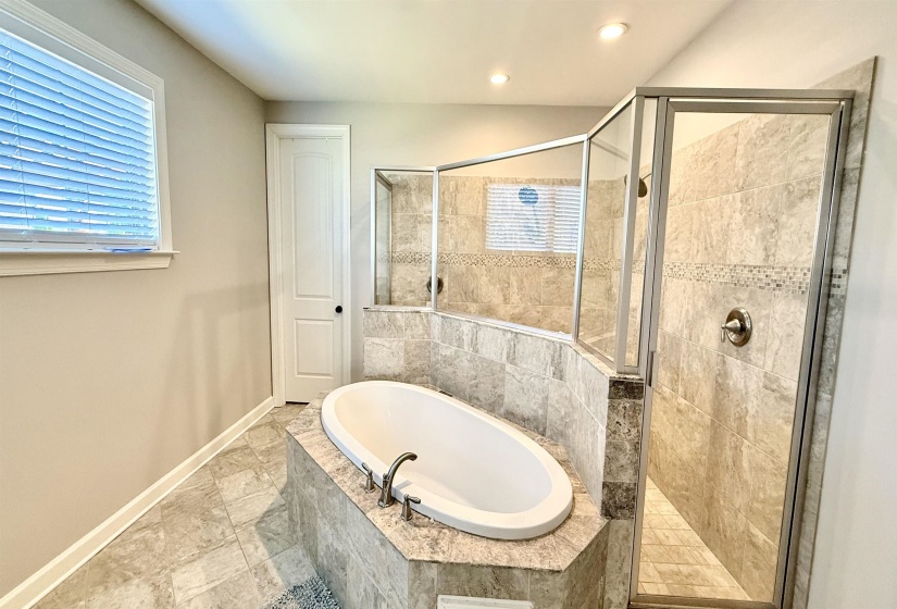 Full bath with a shower stall, a bath, and recessed lighting