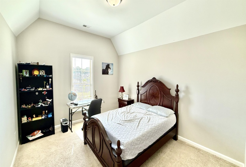 Bedroom with lofted ceiling and light carpet