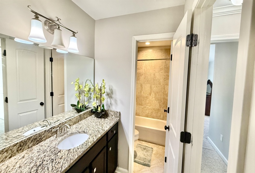 Bathroom with vanity, shower / tub combination, and light tile patterned floors