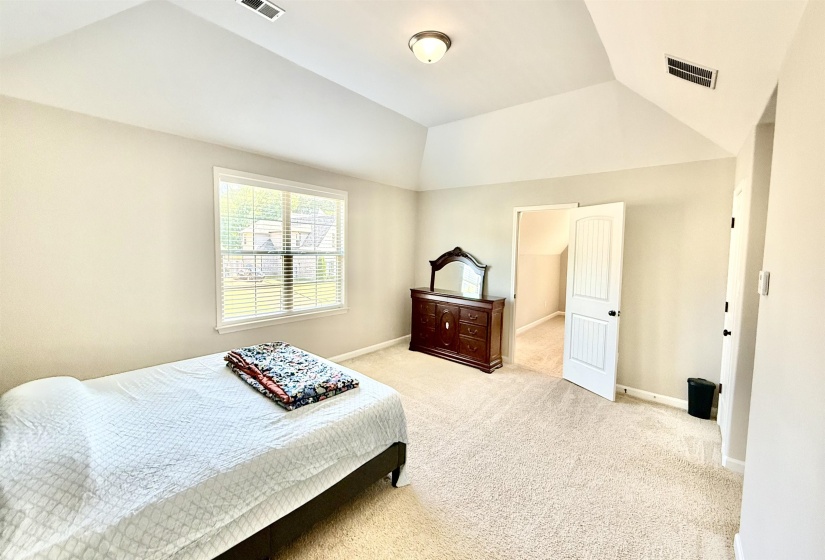 Bedroom with carpet floors and vaulted ceiling