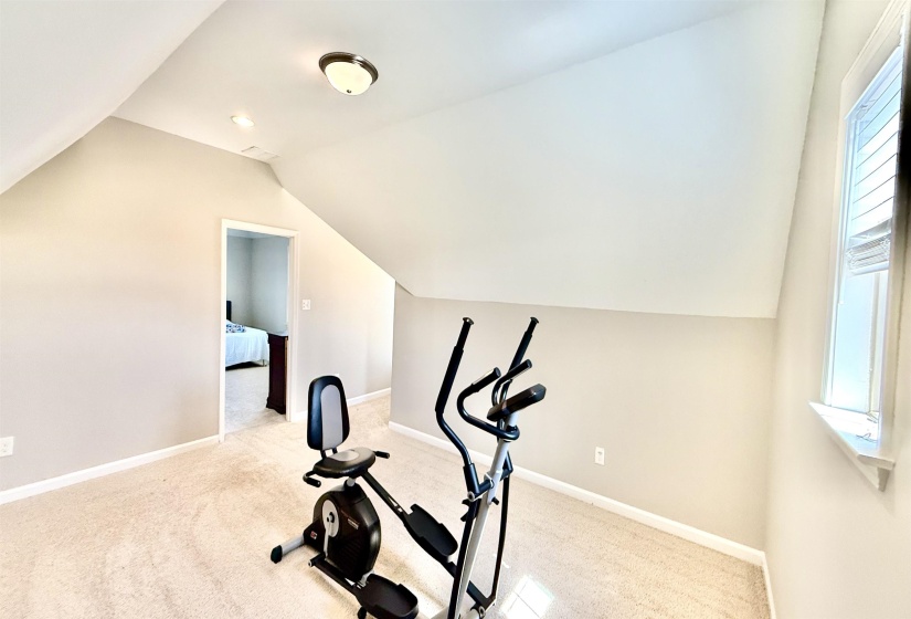 Exercise area with carpet flooring and lofted ceiling