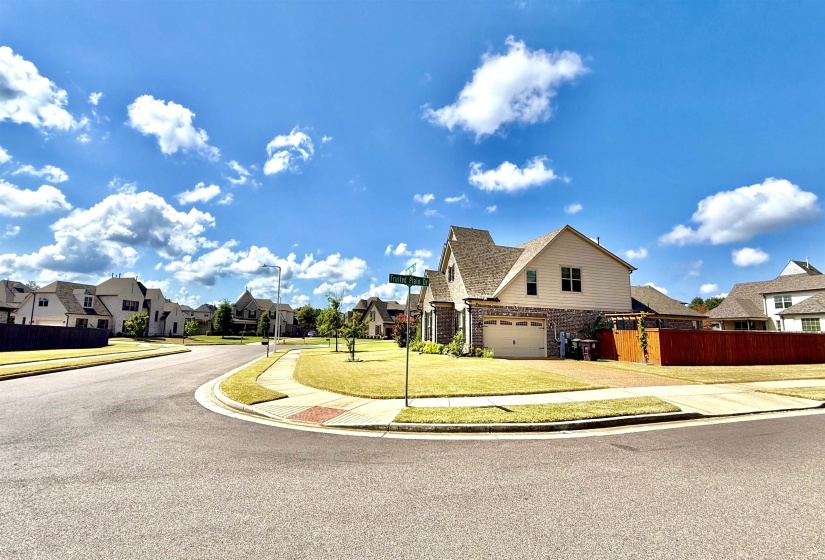 View of asphalt road featuring sidewalks, a residential view, curbs, and street lighting