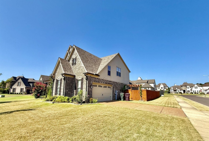 View of home's exterior with brick siding, a residential view, concrete driveway, an attached garage, and roof with shingles