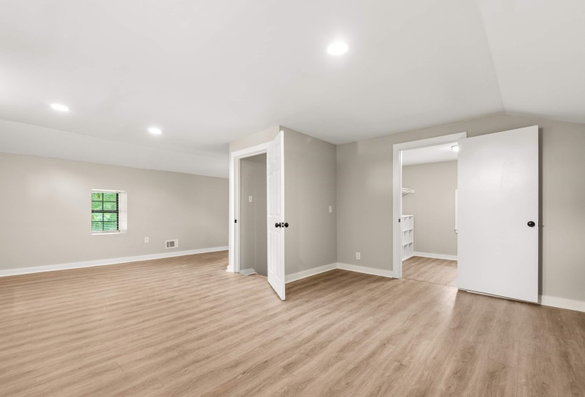 Spacious room featuring wood-finish flooring, recessed lighting, and neutral wall tones