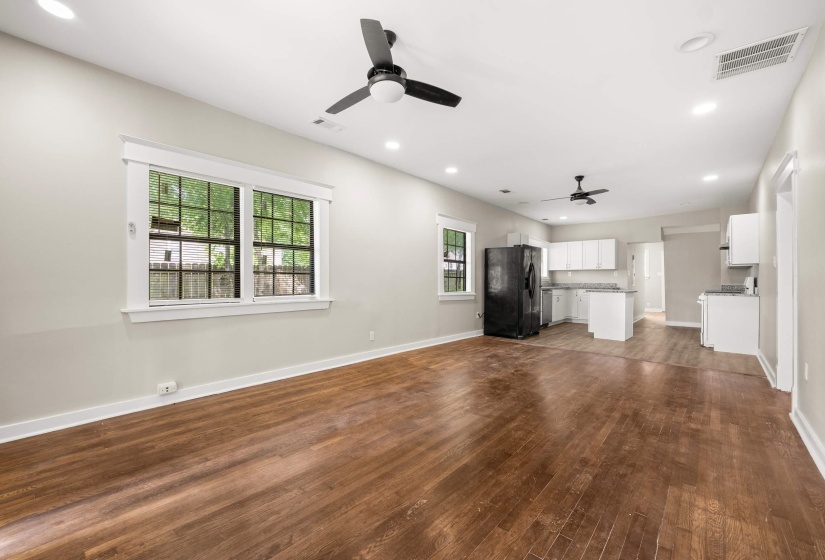 Open-concept living area featuring wood-finish flooring, recessed lighting, and two ceiling fans