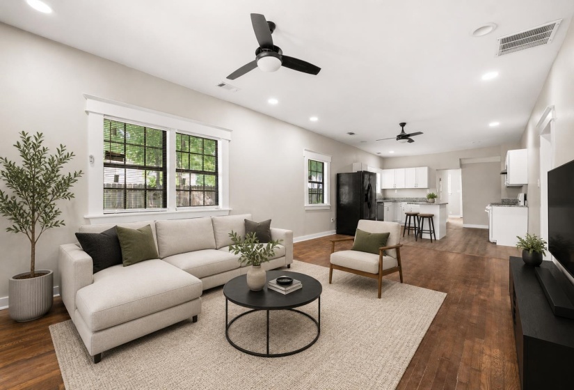 Open-concept living area featuring wood-finish flooring, recessed lighting, and ceiling fans