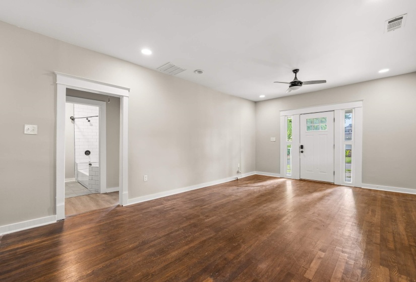 Expansive room featuring rich wood-finish flooring, recessed lighting, and a modern ceiling fan