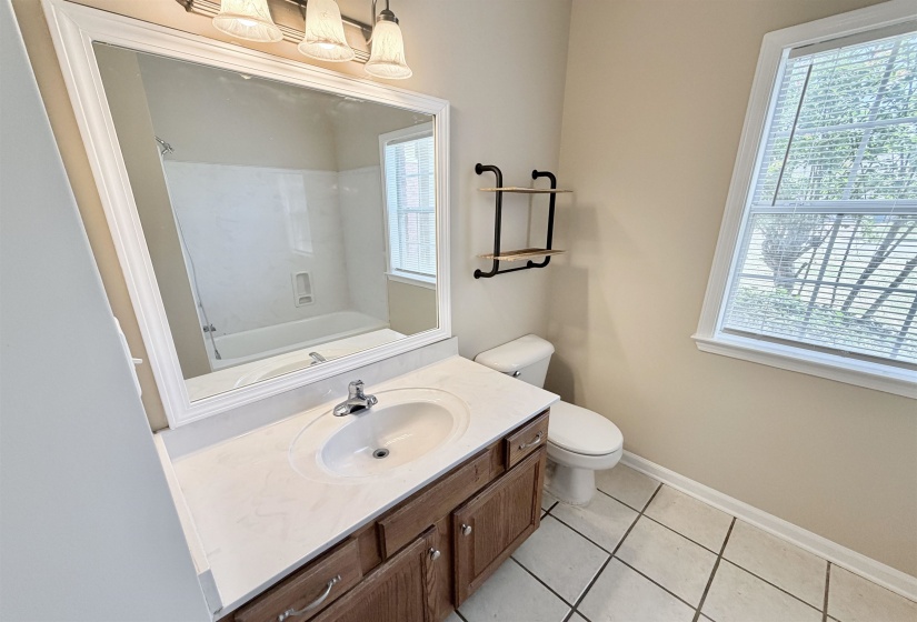 Bathroom vanity with a white countertop and undermount sink, complemented by a rectangular framed mirror