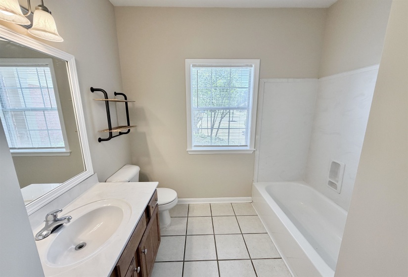 Bathroom featuring a single vanity with wood-finish cabinetry, a white countertop, and an undermount sink
