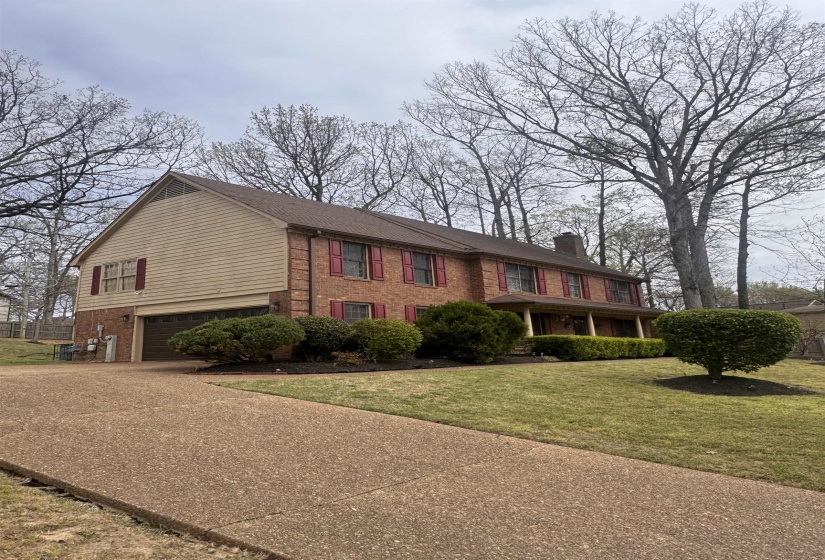 Traditional two-story brick residence featuring a prominent gabled roofline and an attached garage