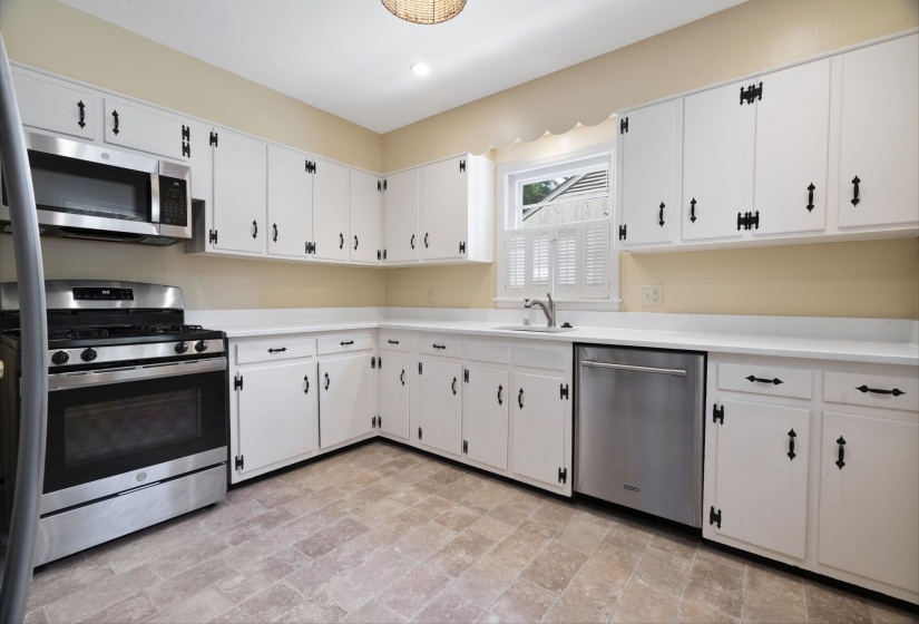 Kitchen featuring white cabinetry, new quartz countertops, and stainless steel appliances