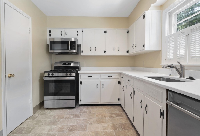 Kitchen featuring white cabinetry, new quartz countertops, and stainless steel appliances