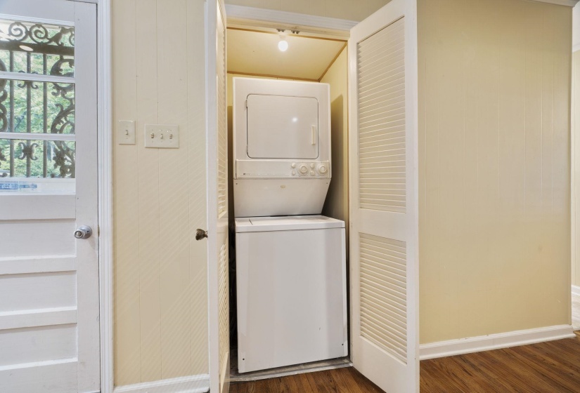 Laundry closet with a stacked washer and dryer, featuring bi-fold louvered doors