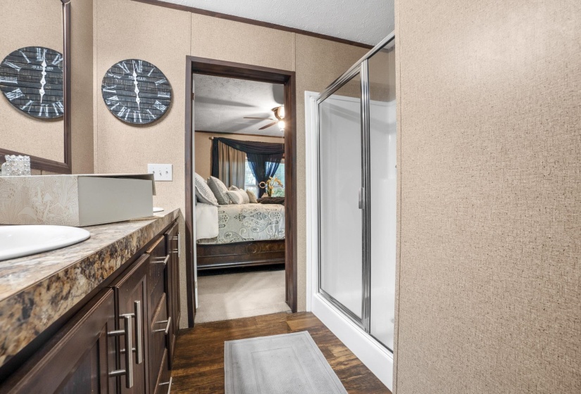 Bathroom vanity with an integrated basin, a dark wood-finish cabinet, and a multi-toned countertop