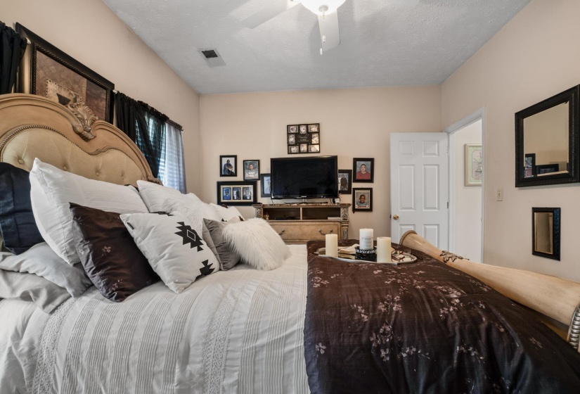 Room featuring a neutral wall color, white ceiling fan, and white trim door