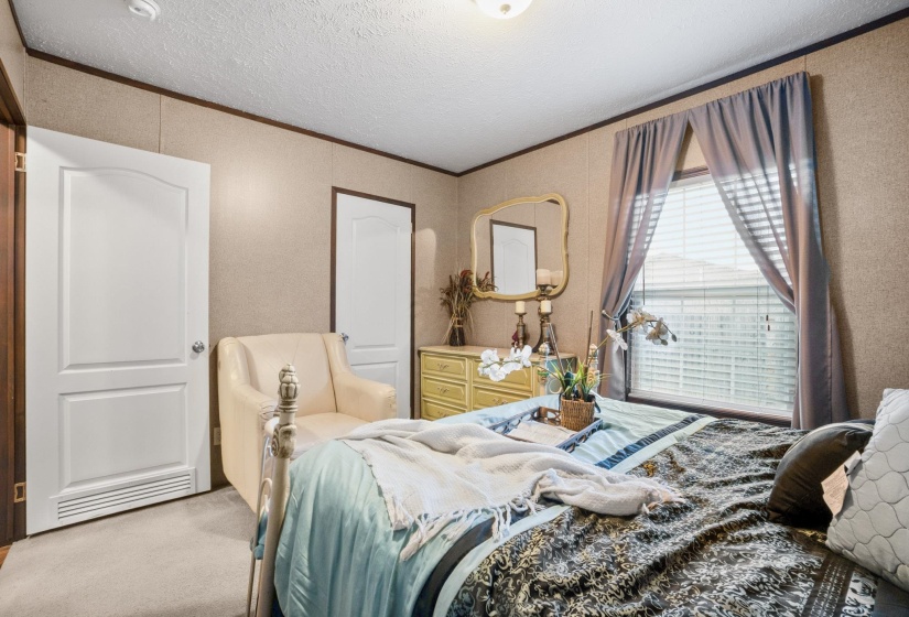 Bedroom with neutral-toned wall paneling and overhead lighting