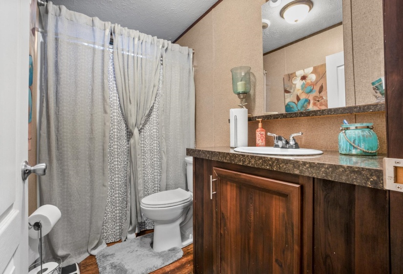 Bathroom featuring a vanity with an integrated sink, a dark countertop, and wood-finish cabinetry
