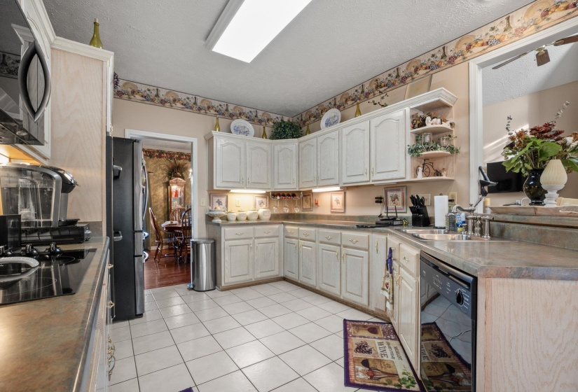 Kitchen featuring white cabinetry with under-cabinet lighting, a black built-in dishwasher, and a black built-in refrigerator