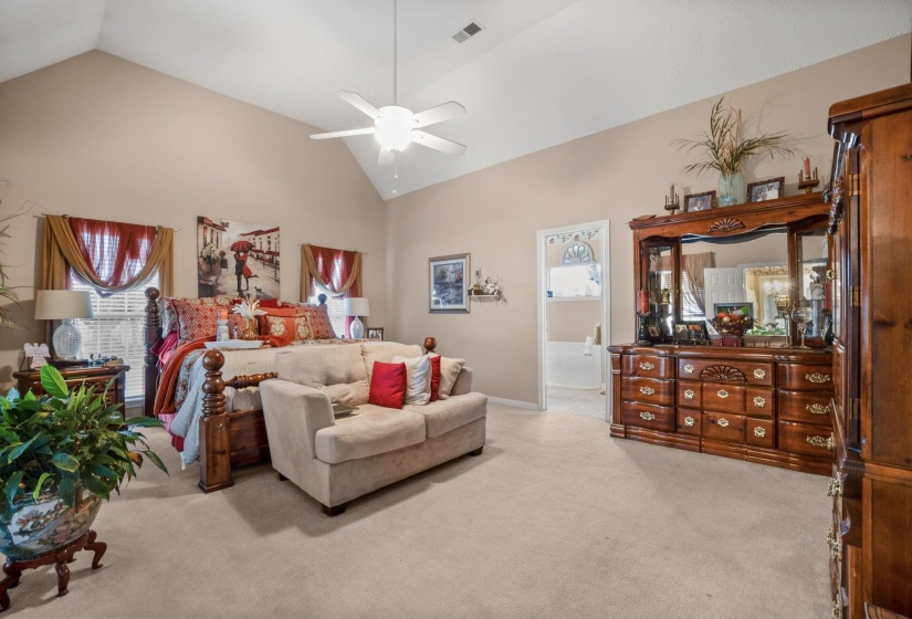 Spacious room featuring vaulted ceilings, neutral-toned walls, and plush carpeting