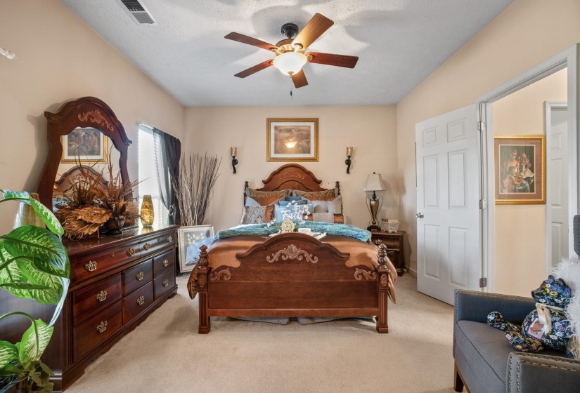 Spacious bedroom featuring light-toned walls and neutral carpeting