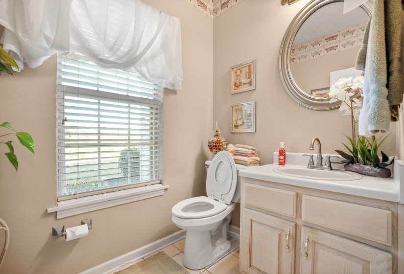 Bathroom featuring a single-sink vanity with white countertop, chrome faucet, and under-sink cabinetry