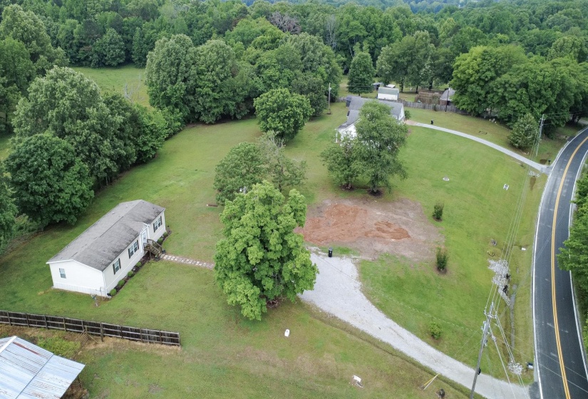 Expansive lot with a single-story dwelling featuring a light-colored exterior and dark window shutters