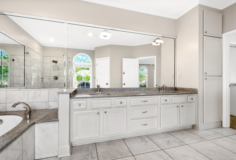 Dual vanity with granite countertops, integrated sinks, white cabinetry, and brushed nickel hardware